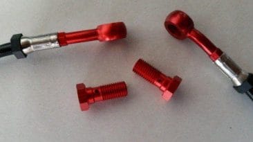 Stahlflex-Bremsleitung schwarz ummantelt mit roten Anschlüssen und Schrauben
